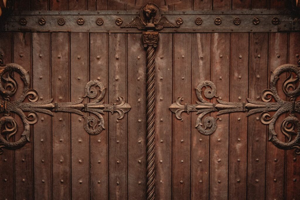 pexels photo 34915486 Close-up of ornate wooden church doors featuring detailed ironwork carvings and rustic charm.