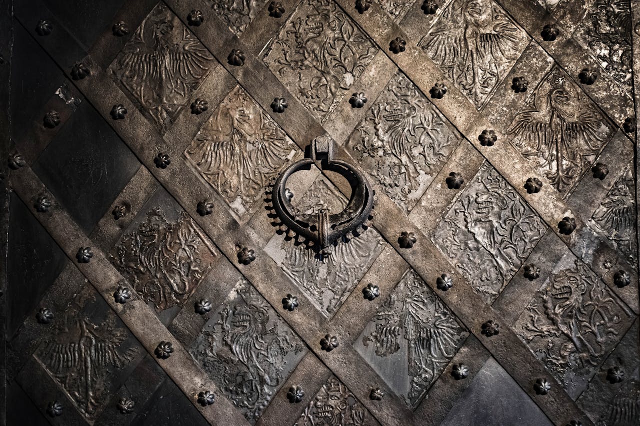 Close-up of a detailed metal door in Nuremberg, Germany displaying ornate medieval designs and a circular handle.