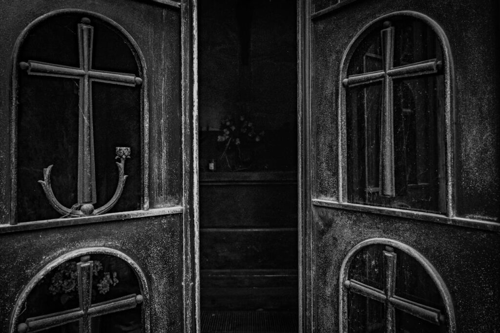 pexels photo 36309974 A vintage iron church door featuring ornate cross designs, inviting a glimpse into the sacred interior.