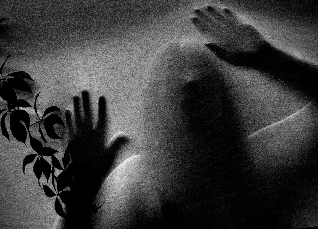 pexels photo 8383072 Mysterious figure with hands pressed against frosted glass, evoking a spooky atmosphere.